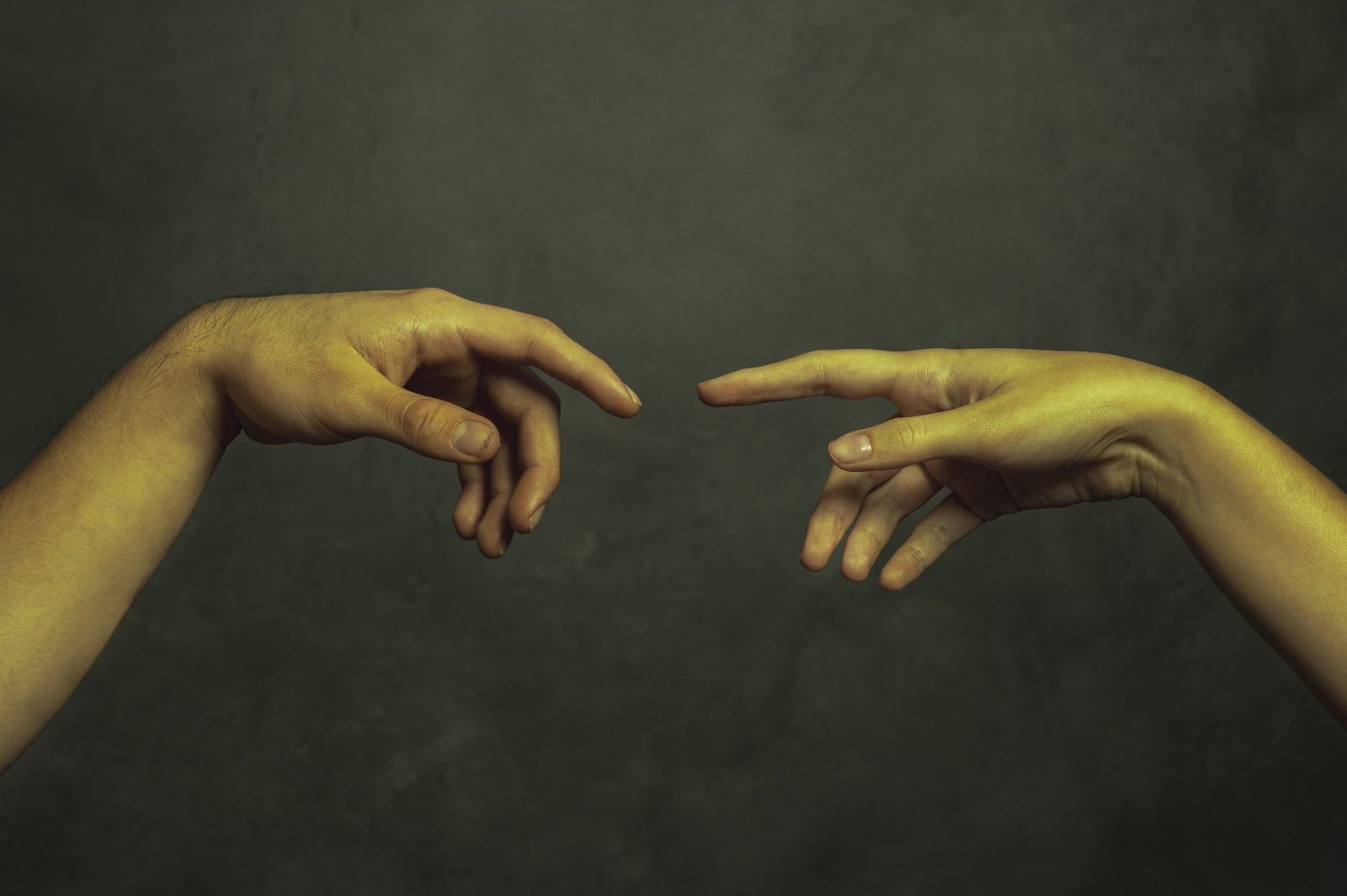 Two hands reaching for each other in a green and yellow background.